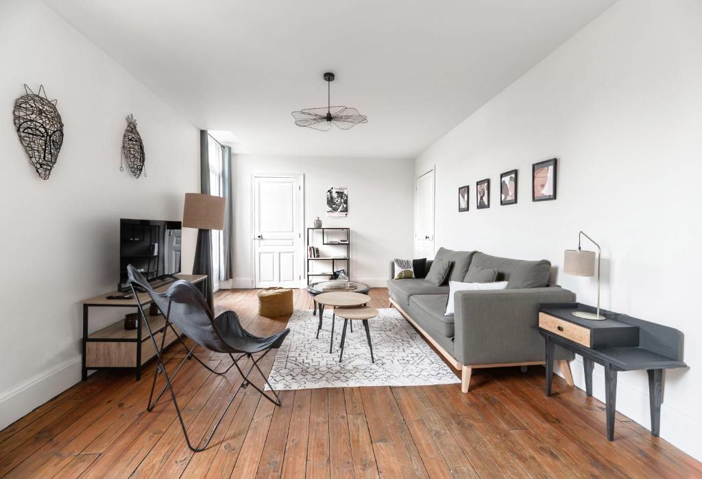 ein Wohnzimmer mit Sofa und Tisch in der Unterkunft Résidence Epinat - Appartements centre & parking in Vichy