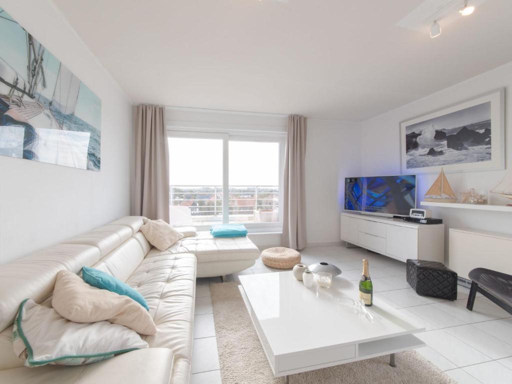 a white living room with a couch and a table at Apartment Ref- 164 by Interhome in Bredene-aan-Zee
