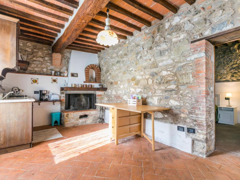 kuchnia z kamienną ścianą i drewnianym stołem w obiekcie Apartment Irene by Interhome w mieście Montieri