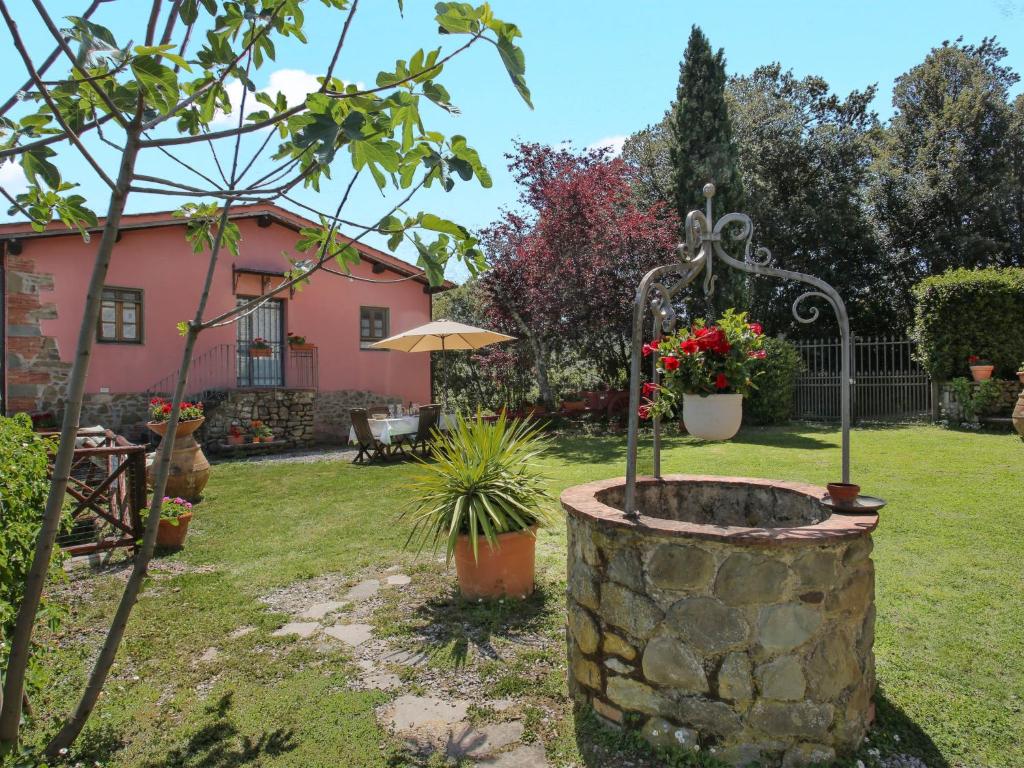 a garden with a stone planter in front of a house at Holiday Home Le Poggiole-1 by Interhome in Cavriglia