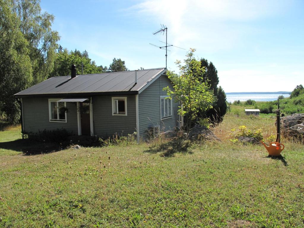 una pequeña casa en medio de un campo en Chalet Lindby Pärlan - STH150 by Interhome en Adelsö