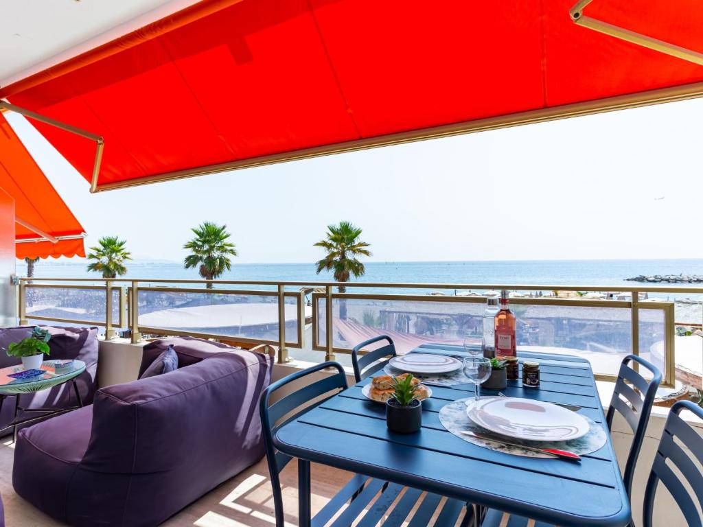 une table à manger sur un balcon avec vue sur l'océan dans l'établissement Apartment de la mer by Interhome, à Villeneuve-Loubet