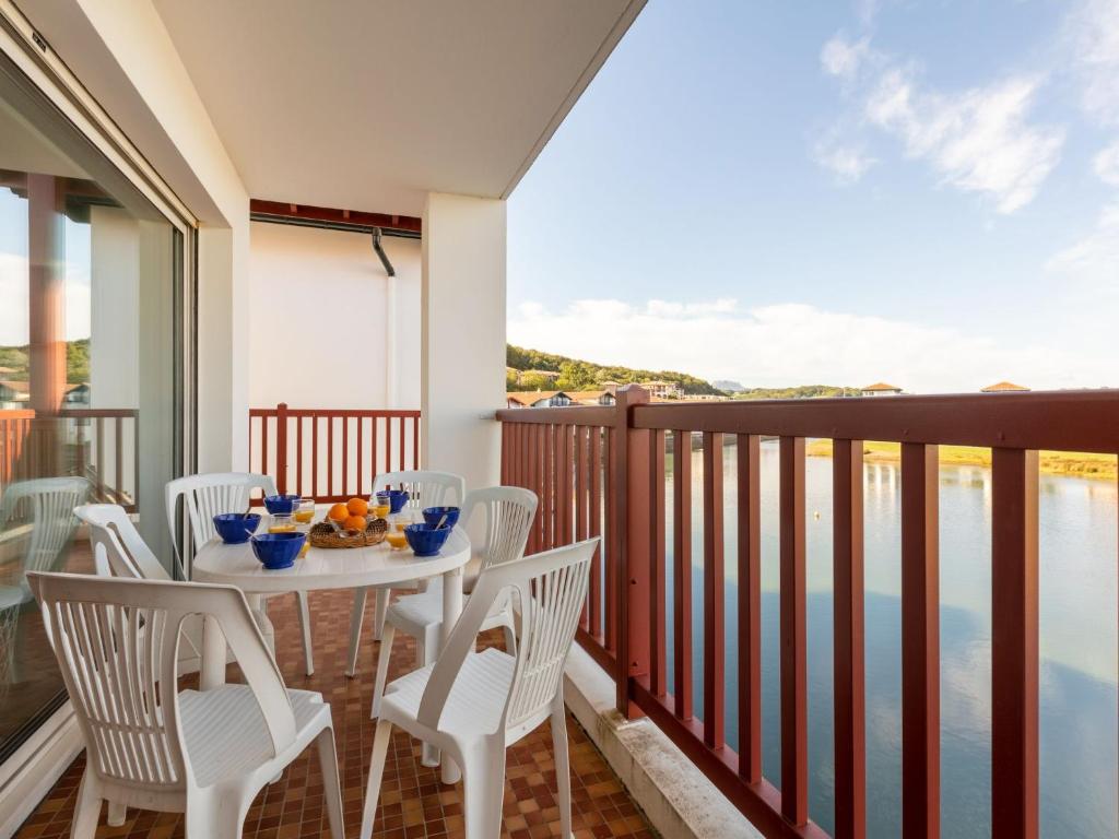 una mesa y sillas en un balcón con vistas al agua en Apartment Ederra Untxin by Interhome, en Socoa