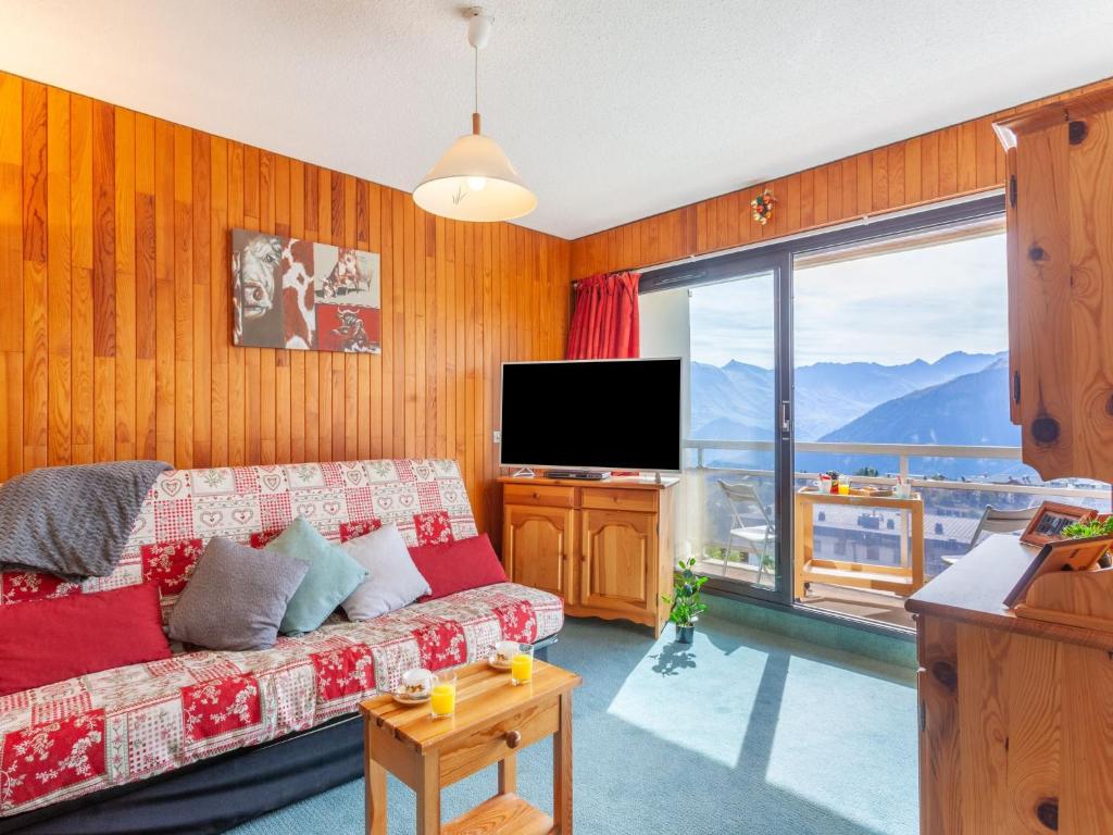 ein Wohnzimmer mit Sofa und Flachbildfernseher in der Unterkunft Apartment L'Edioule by Interhome in La Toussuire