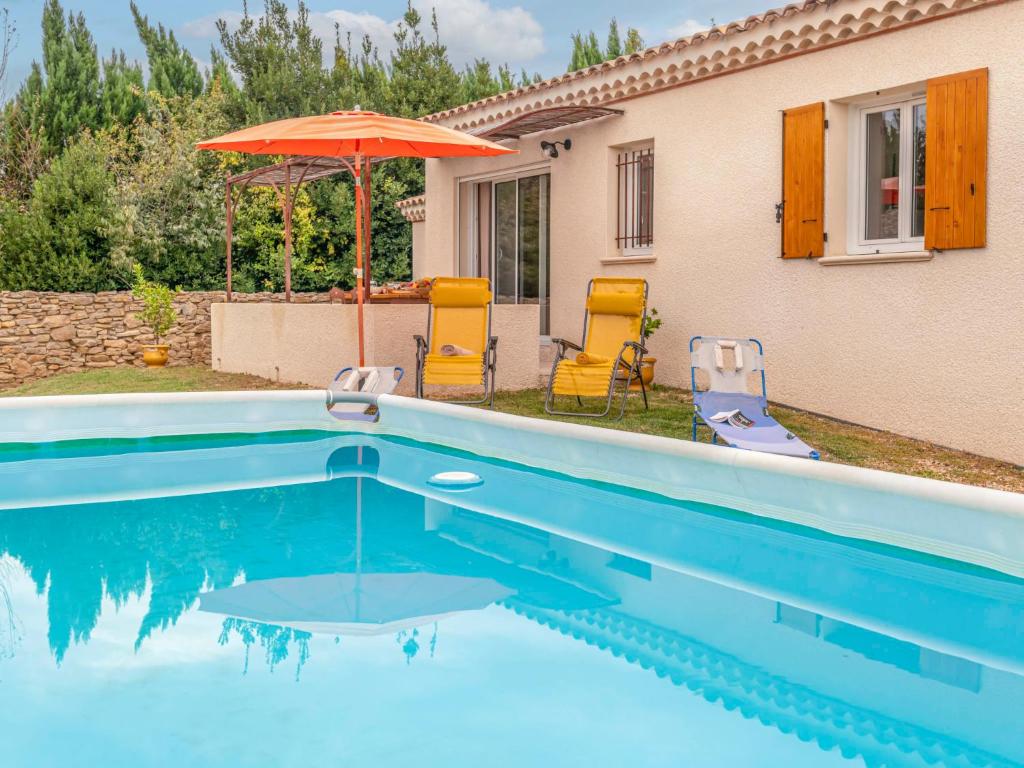 una piscina con 2 sillas y una sombrilla en Holiday Home A la porte d'Avignon by Interhome en Laudun