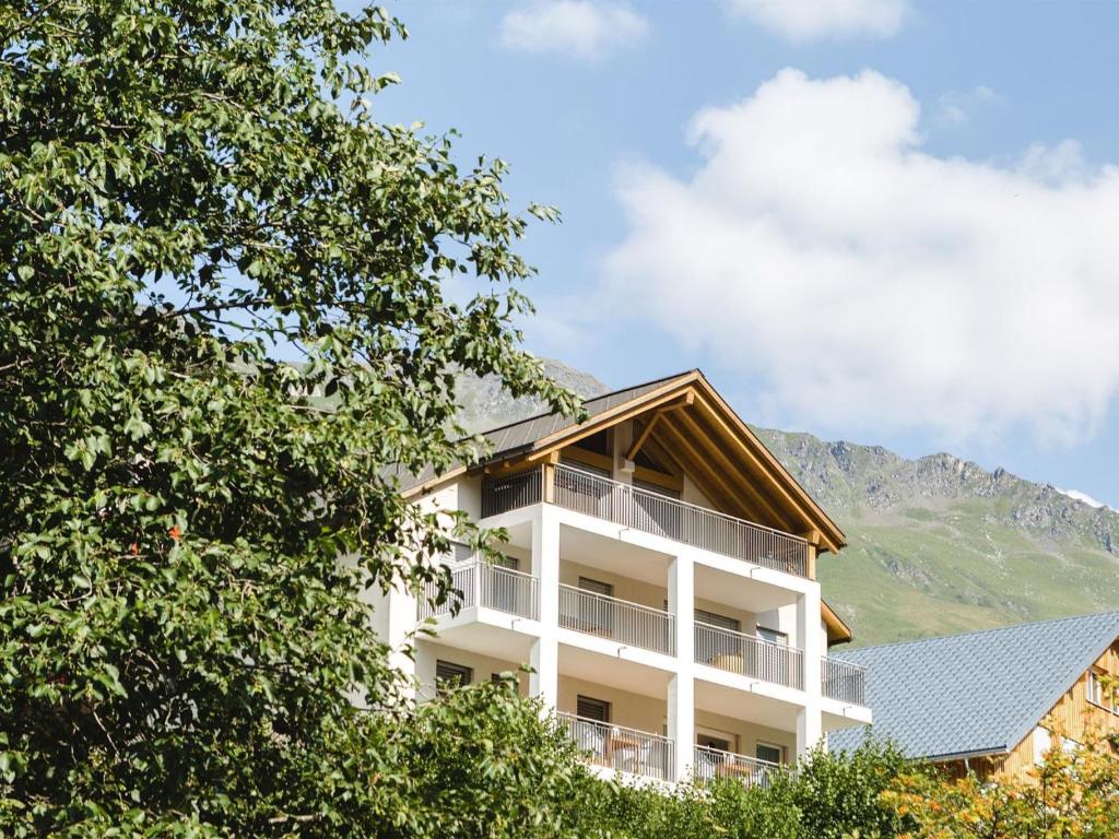 a white building with a mountain in the background at Apartment Liebrand by Interhome in Churwalden