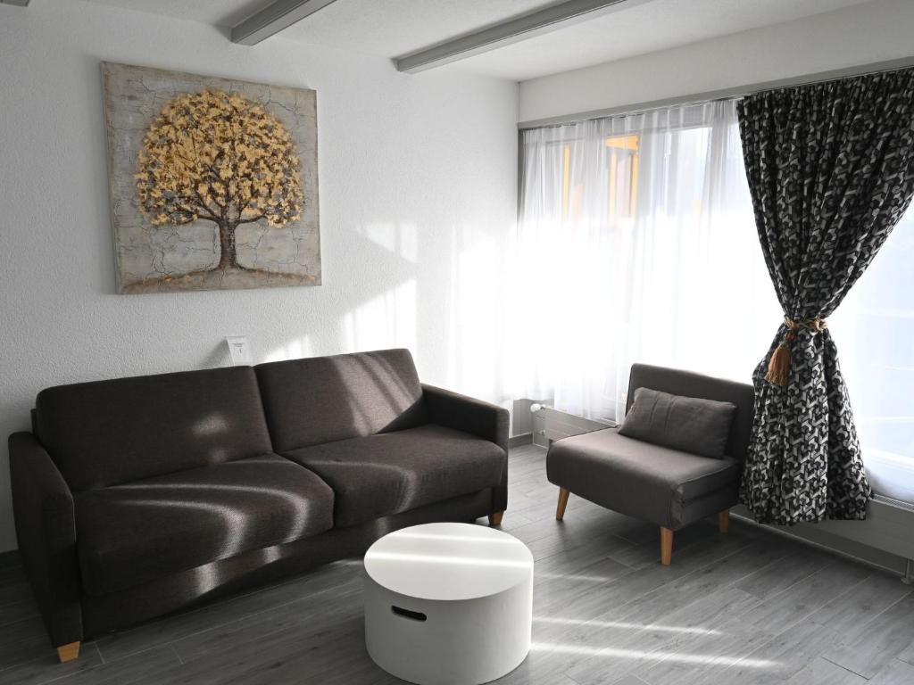 uma sala de estar com um sofá e uma cadeira em Studio Orion RS6 by Interhome em Ovronnaz