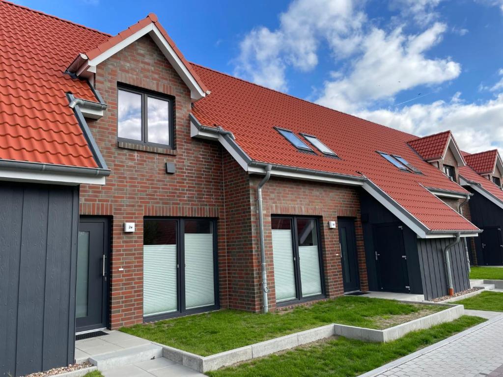 a brick house with a red roof at Holiday Home Cuxland Ferienpark-5 by Interhome in Wremen