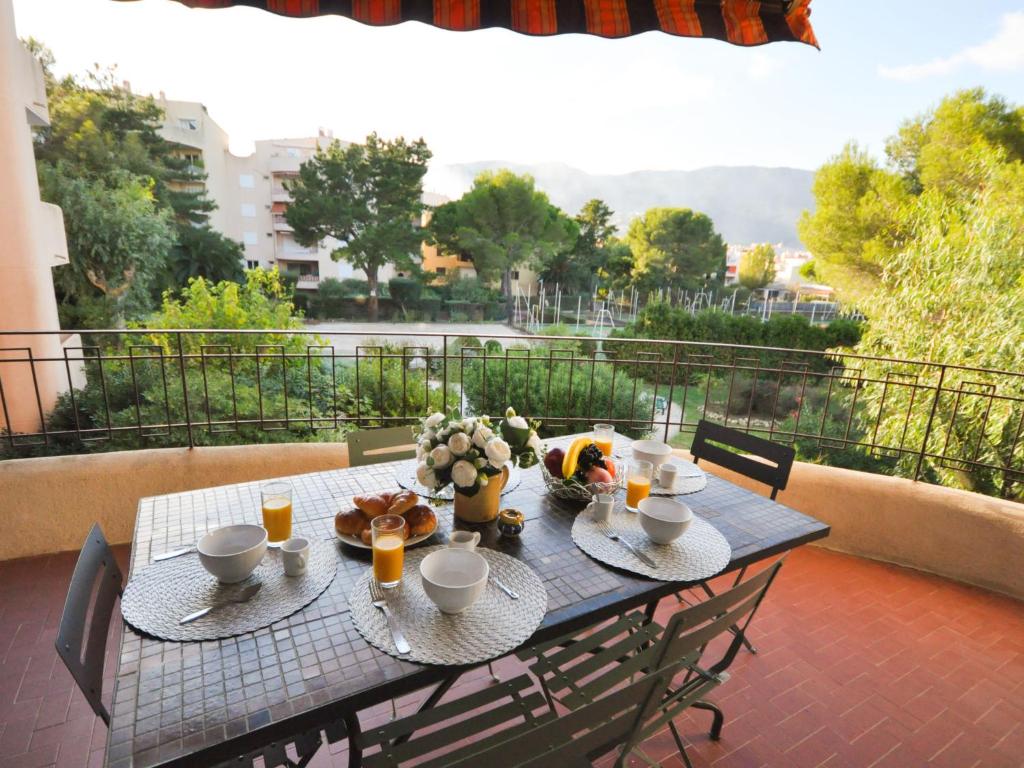 une table avec de la nourriture et des boissons sur un balcon dans l'établissement Apartment Porto di Mar-10 by Interhome, à Cavalaire-sur-Mer