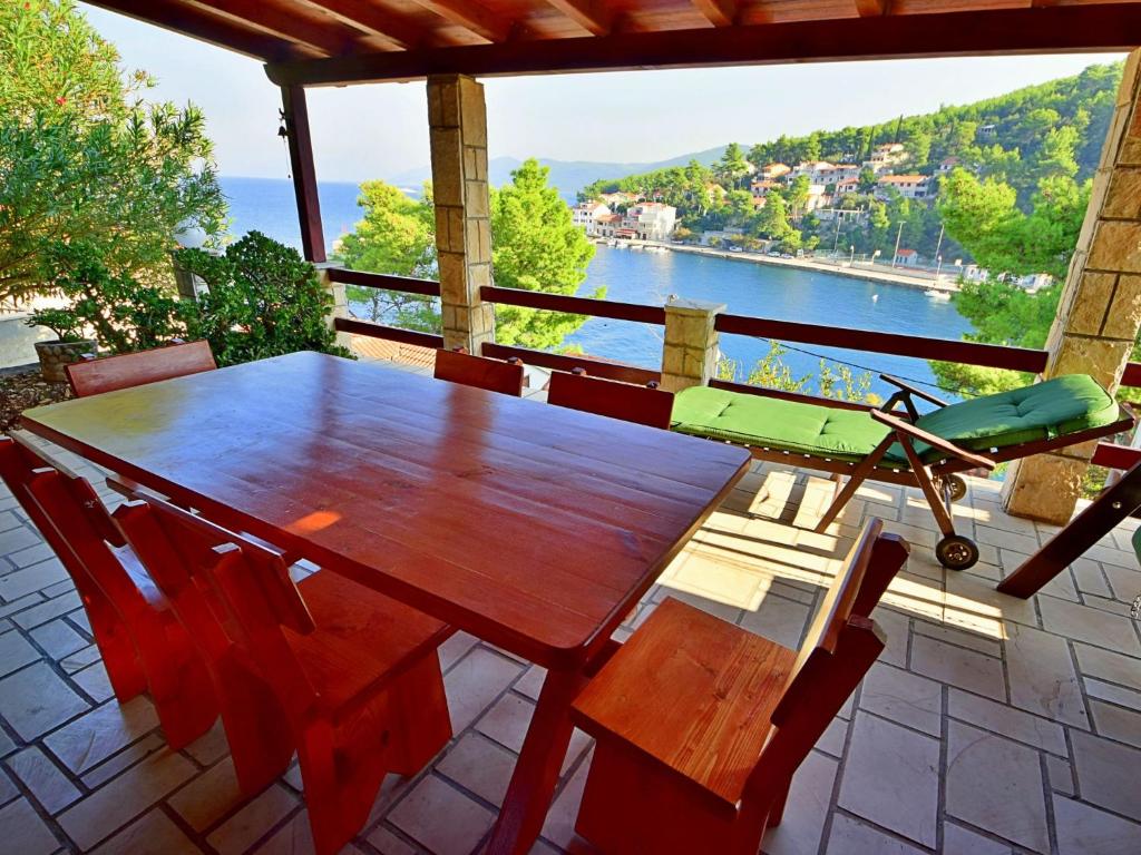 einen Holztisch und Stühle auf einem Balkon mit Blick auf das Wasser in der Unterkunft Holiday Home Peter by Interhome in Prigradica