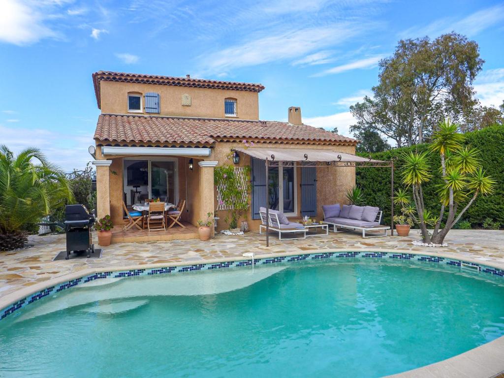 une villa avec une piscine en face d'une maison dans l'établissement Villa Villa Les Galandos by Interhome, à Saint-Aygulf