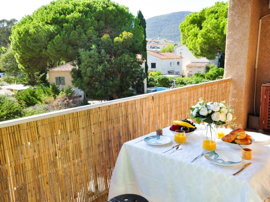 - une table avec de la nourriture et des fleurs sur le balcon dans l'établissement Apartment Les Lantanas-2 by Interhome, à Cavalaire-sur-Mer
