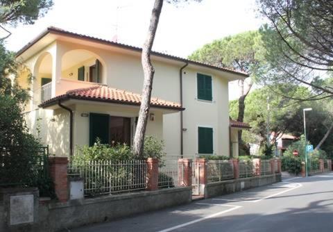 a white house with a fence in front of a street at Volturnus a soli 150m dal mare con WI FI in Marina di Castagneto Carducci