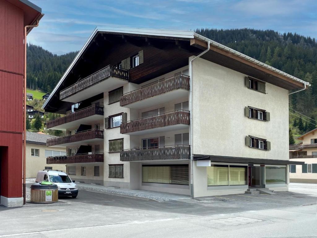 an apartment building with balconies and a car parked in a parking lot at Apartment Seeli by Interhome in Churwalden