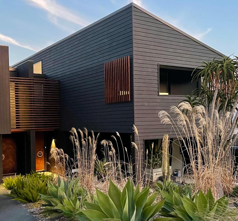 a black house with plants in front of it at Hyams Beach House A - Brand new lux beach Oasis in Hyams Beach