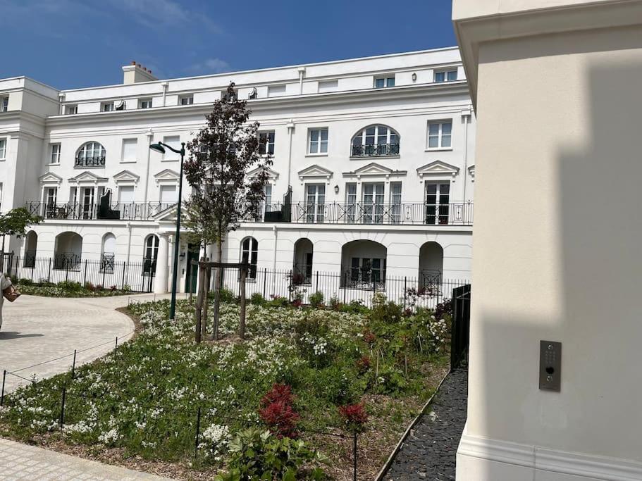a large white building with a garden in front of it at Superbe appartement très confortable in Serris