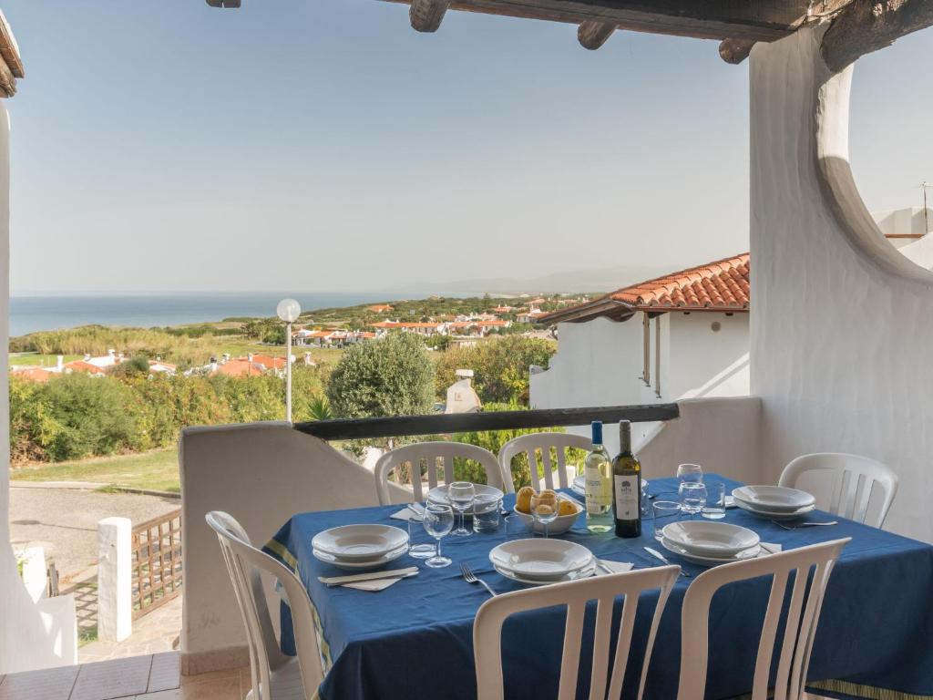 una mesa con un paño de mesa azul y sillas en el balcón en Holiday Home Valentina by Interhome, en Valledoria