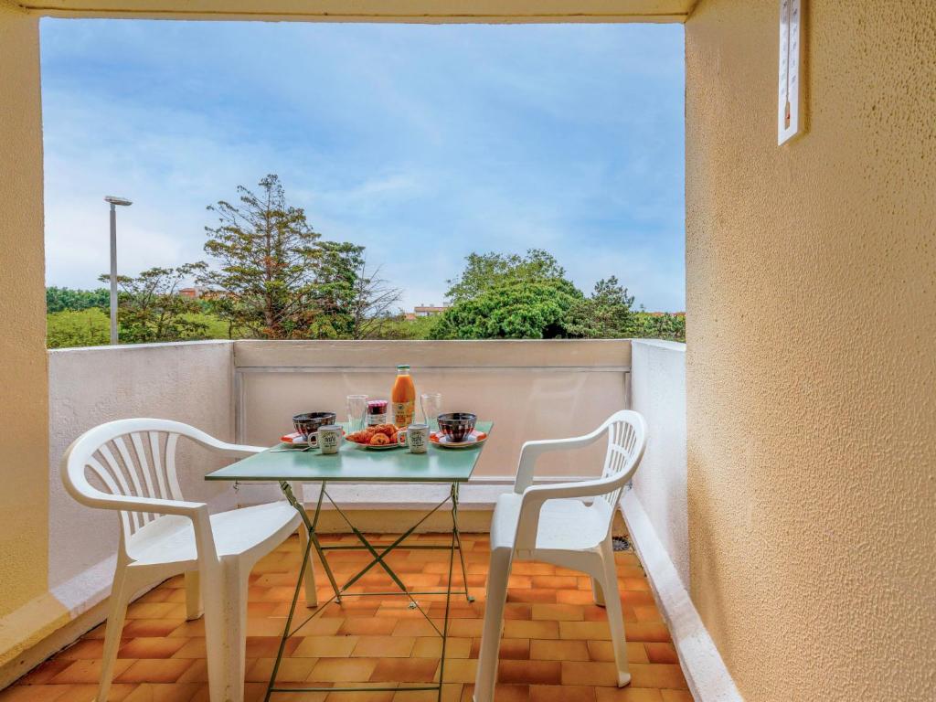 a table and two chairs on a balcony at Apartment Palm Beach by Interhome in Cap d'Agde
