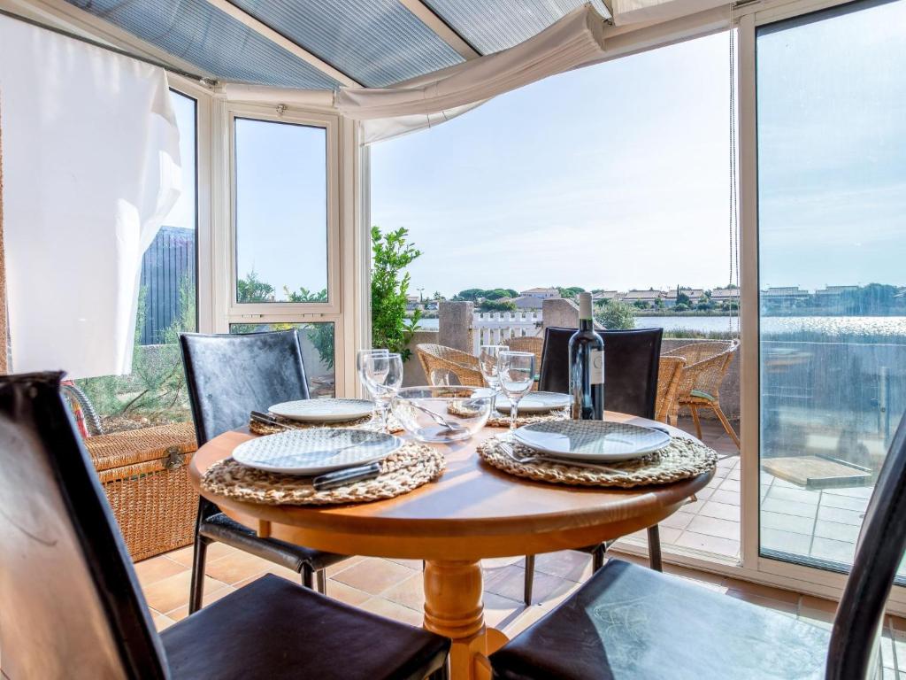 - une salle à manger avec une table et une vue sur l'eau dans l'établissement Holiday Home Belle Ile 1 by Interhome, à Gruissan