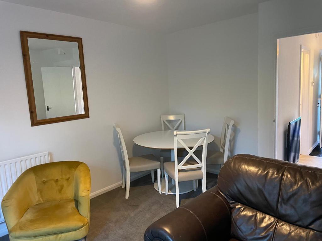 een woonkamer met een bank, een tafel en een spiegel bij Serviced Accommodation 2 bed house III in Hindlip