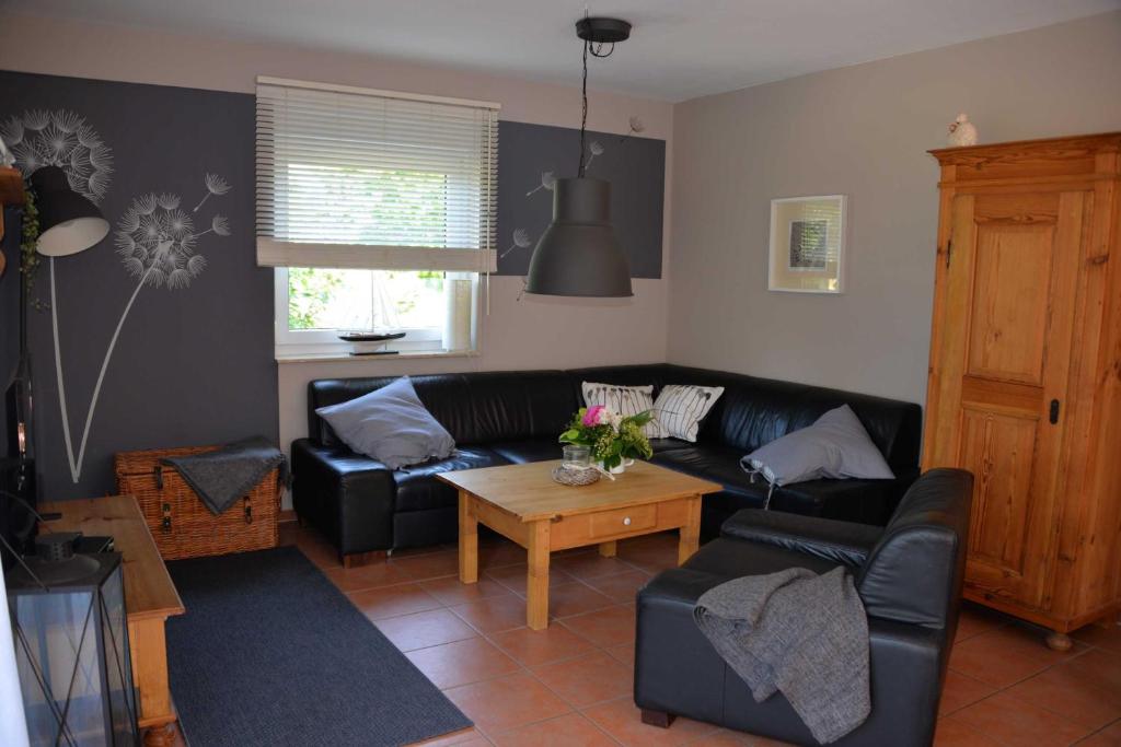 ein Wohnzimmer mit einer schwarzen Couch und einem Tisch in der Unterkunft Ferienhaus 8erwassereck in Ückeritz