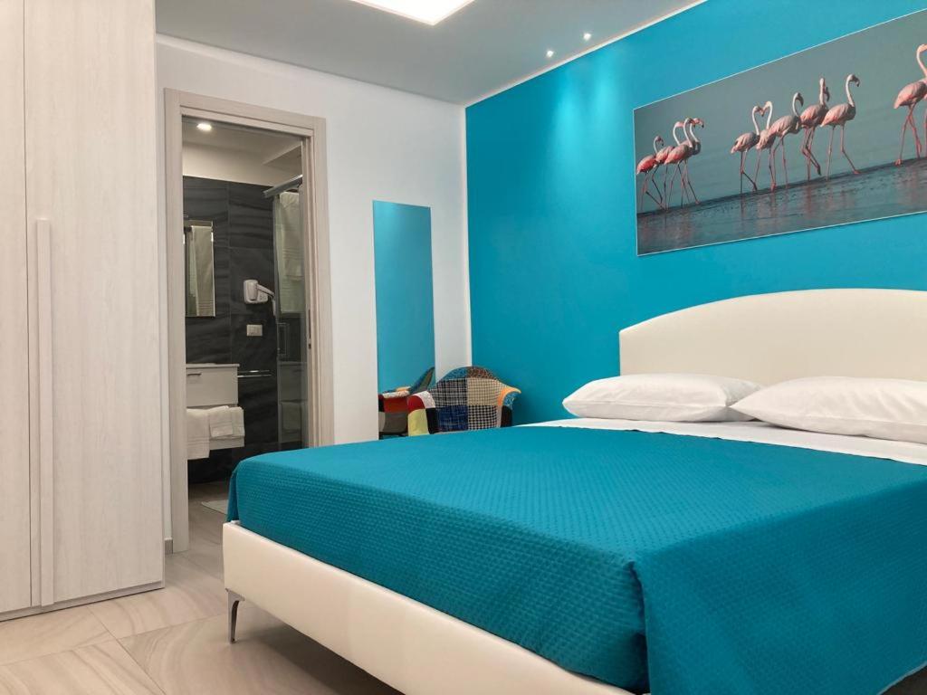 LA DARSENA rooms في مارغريتا دي سافويا: غرفة نوم زرقاء مع سرير بجدار ازرق