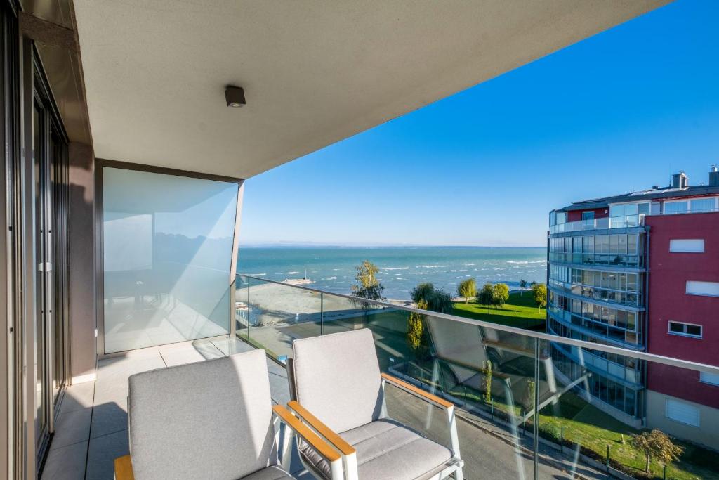 dwa krzesła na balkonie z widokiem na ocean w obiekcie MF Casa Coral Apartment w Siófoku