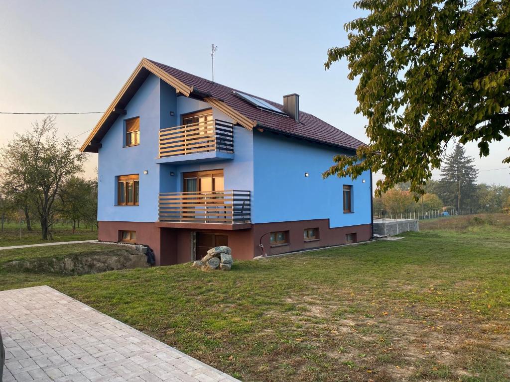 niebieski dom z balkonem na dziedzińcu w obiekcie VILLA 1378 ERDUT w mieście Erdut