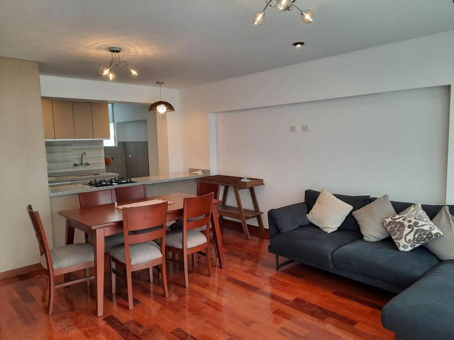 a living room with a couch and a table at Waraqu Wasi Hermoso y acogedor departamento,zona residencial in Cusco