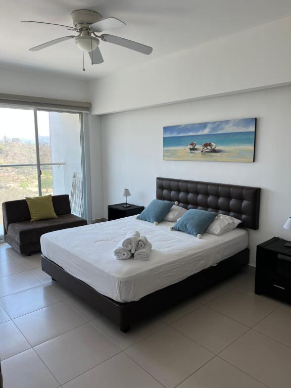 Resort Playa Azul Departamentos frente al mar في تونسوبا: غرفة نوم بسرير كبير وأريكة
