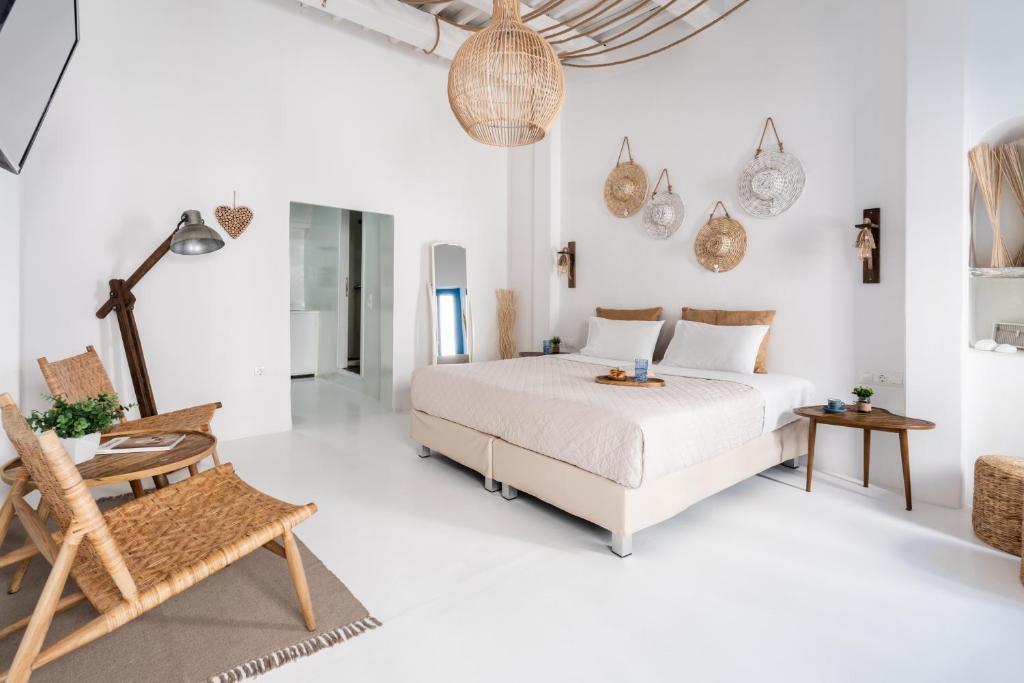 biała sypialnia z łóżkiem i krzesłem w obiekcie Love suite mykonos town w mieście Mykonos