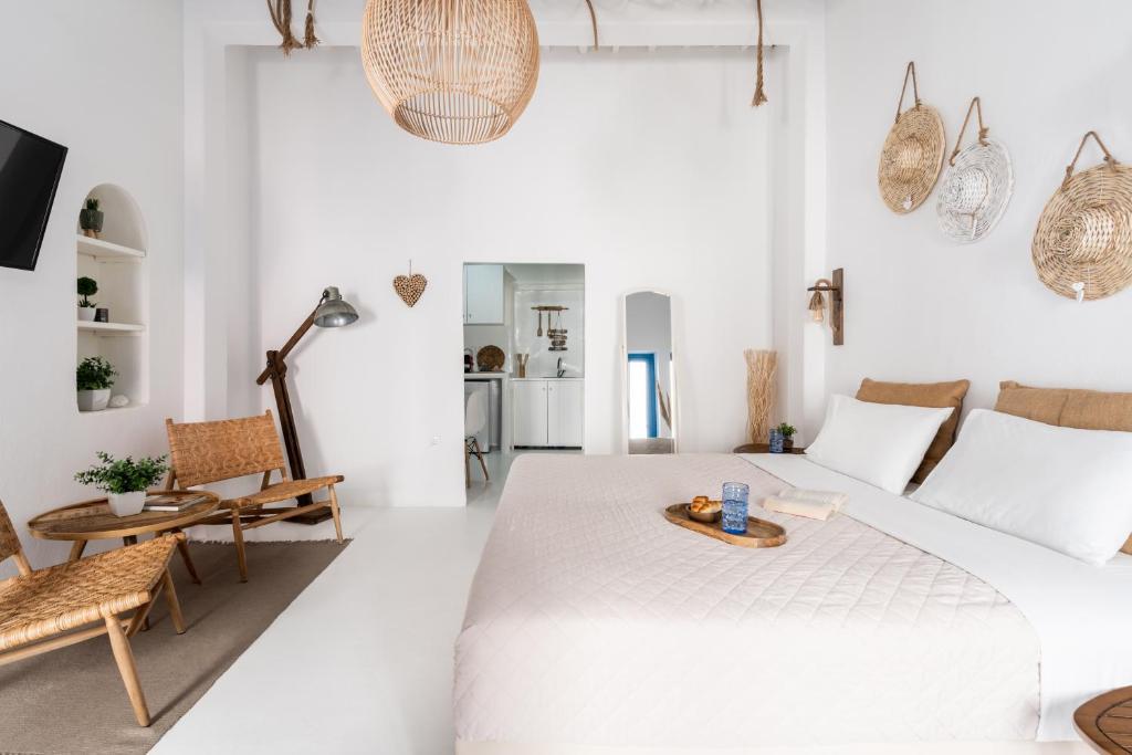 Biały salon z dużym łóżkiem i krzesłami w obiekcie Love suite mykonos town w mieście Mykonos