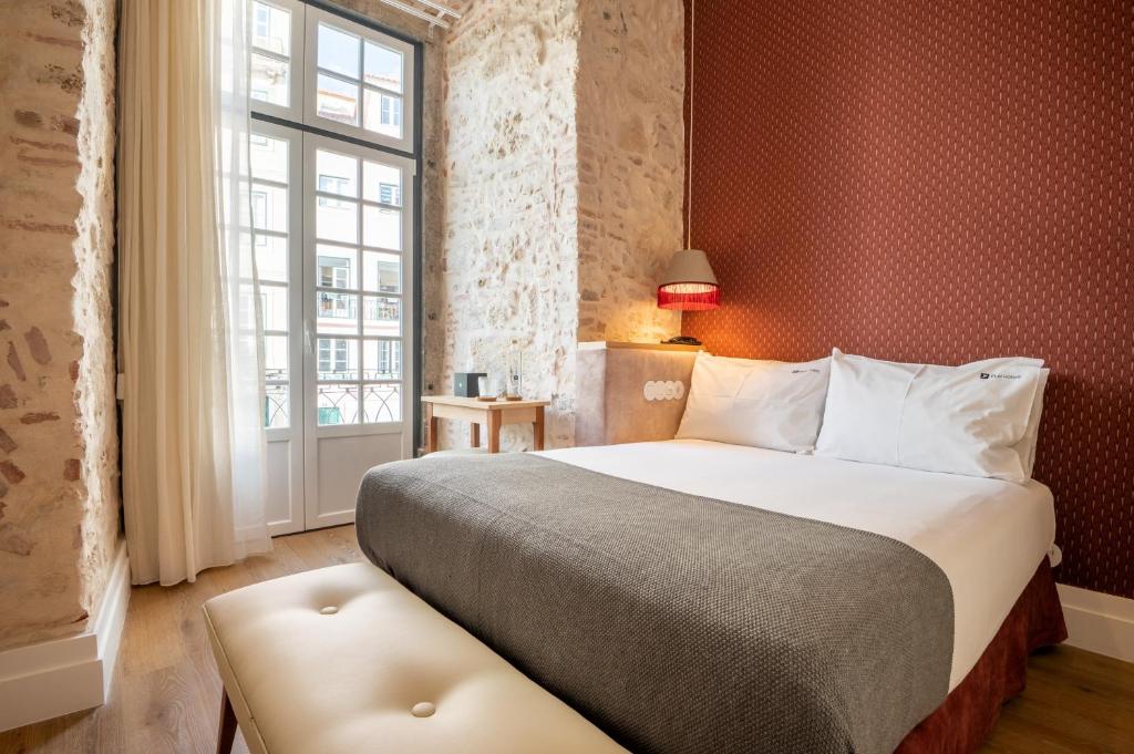 sypialnia z dużym łóżkiem i oknem w obiekcie Boemio FLH Hotels w Lizbonie