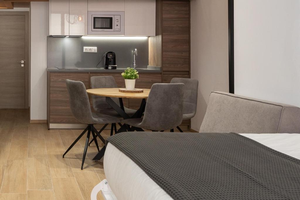 Travel Habitat Benimaclet Vista Hermosa Suites في فالنسيا: غرفة مع طاولة وكراسي ومطبخ