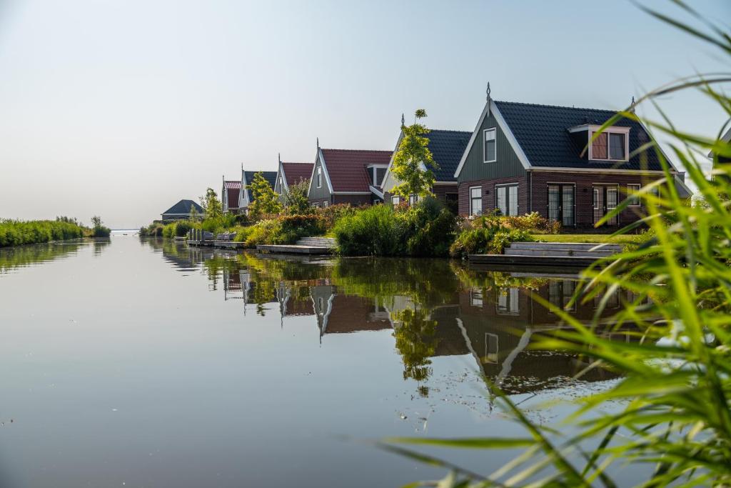 a row of houses next to a canal at EuroParcs Poort van Amsterdam in Uitdam