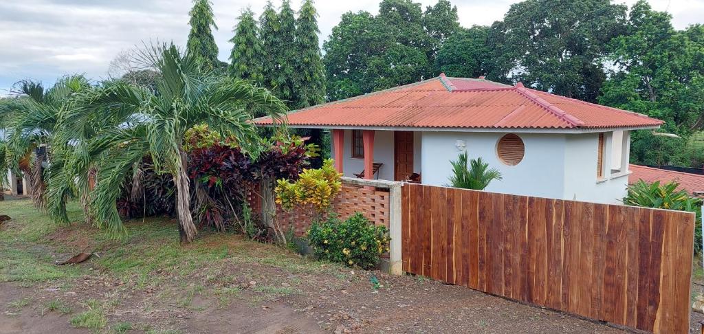 ein weißes Haus mit einem Zaun und einer Palme in der Unterkunft Casa completa/ familiar a 3km de playa el Arenal in Pedasí Town