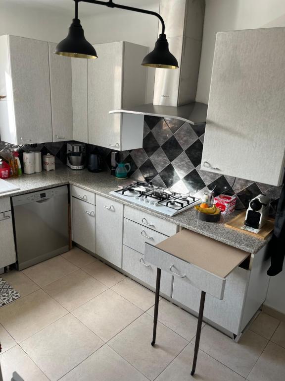 a kitchen with white cabinets and a stove at Villa Victoire au coeur de la Provence in Venelles