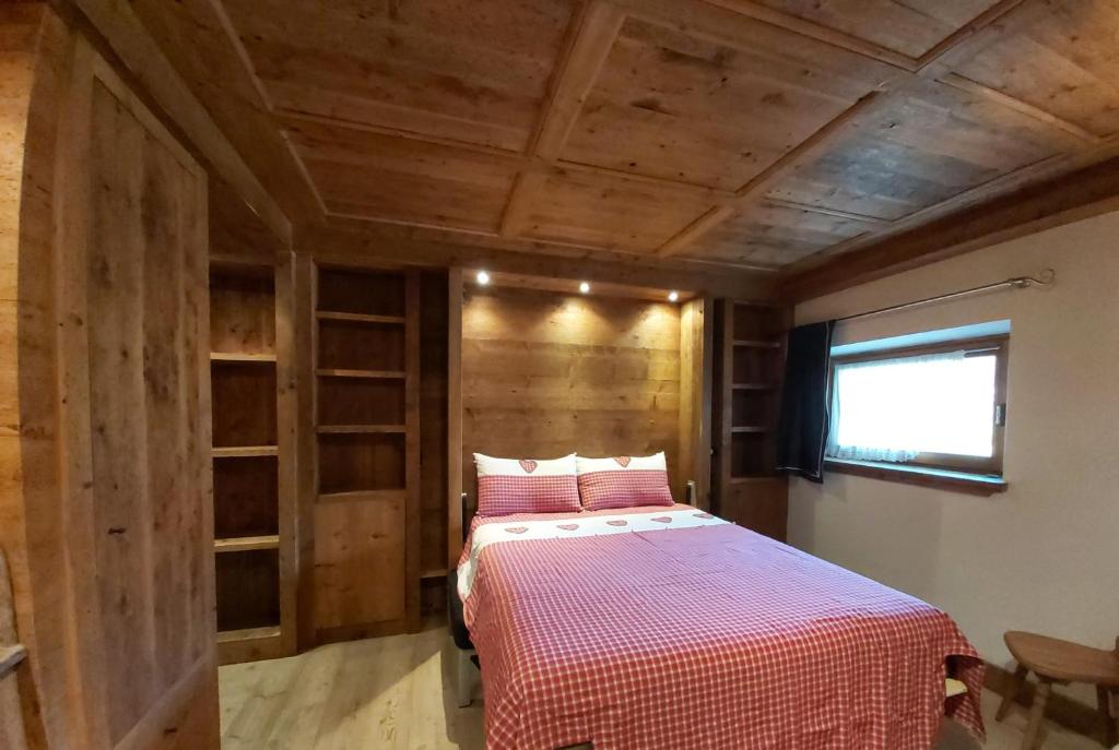 een slaapkamer met een bed in een kamer met houten wanden bij APPARTAMENTO STELLA ALPINA in Cortina dʼAmpezzo