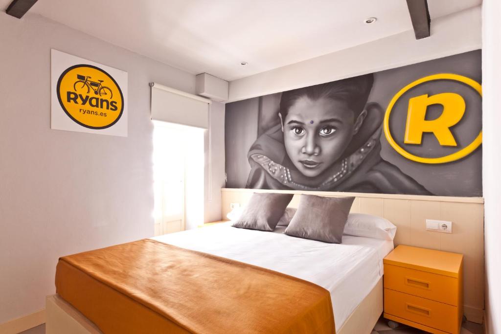 1 dormitorio con 1 cama con una pintura en la pared en Ryans Budget en Ibiza
