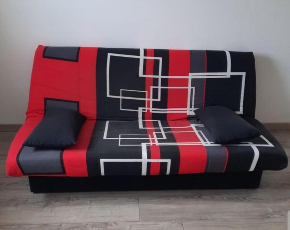 - un canapé rouge noir et blanc dans la chambre dans l'établissement Appartement Rdc avec parking privé, à Bastia