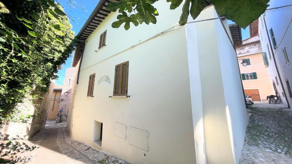 un edificio blanco con ventanas en una calle en huge town house in Spoleto storico - car unnecessary - wifi - sleeps 10, en Spoleto
