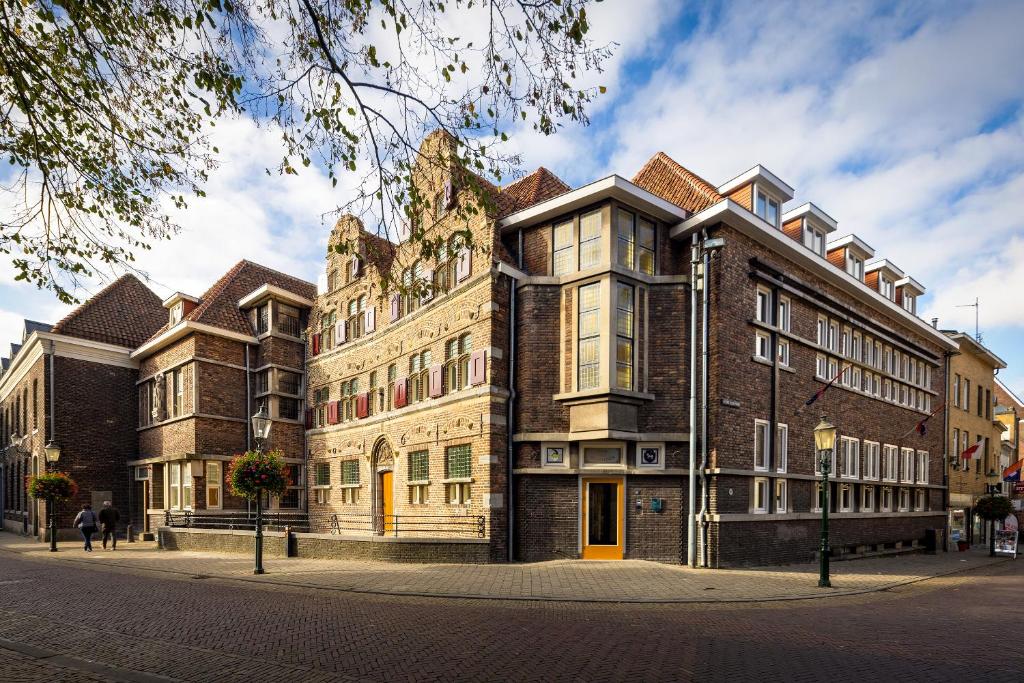 un gran edificio de ladrillo en una calle de la ciudad en Stadsherberg Ald Weishoès - Hostel, en Venlo