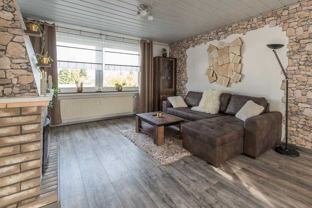 a living room with a couch and a brick wall at Schöne lichtdurchflutete Ferienwohnung mit Balkon in Hagen