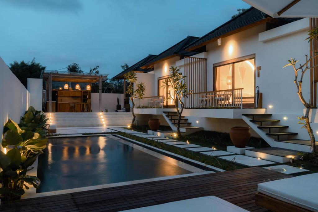 a home with a swimming pool and a house at Sanjula Uluwatu in Uluwatu