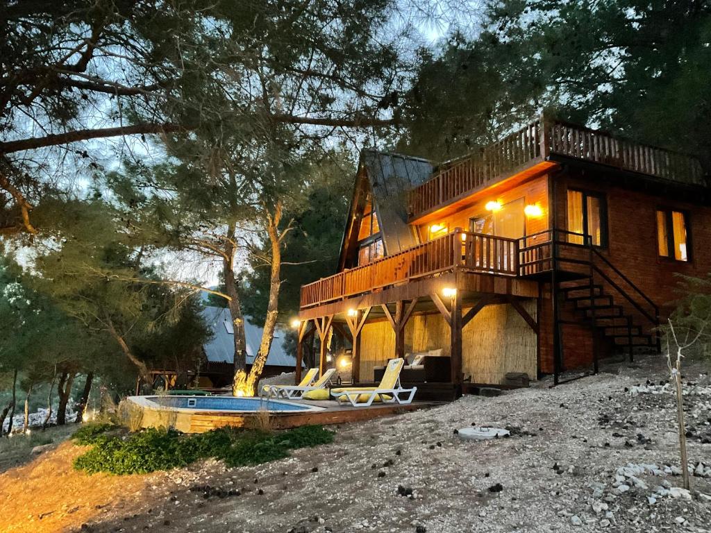 a house with a deck and a swimming pool at Panurla Wooden House havuz & sauna kırmızı in Urla