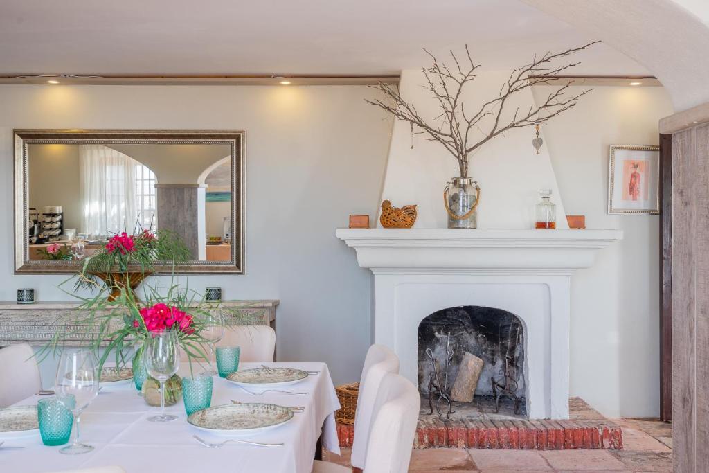 a dining room with a table and a fireplace at La Tartana Hotel Boutique in La Herradura