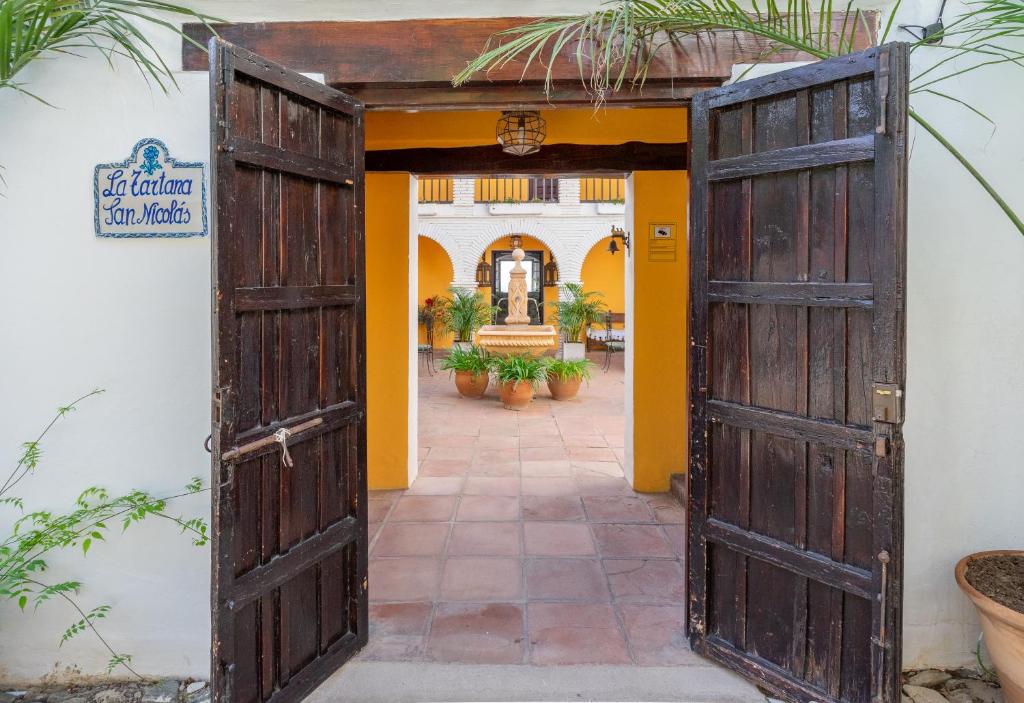 an open door into a courtyard with plants at La Tartana Hotel Boutique in La Herradura