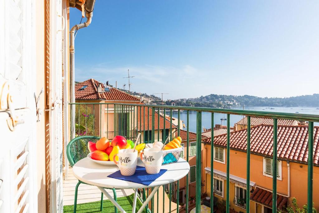 - une table avec un bol de fruits sur le balcon dans l'établissement MAIOUN Villefranche-sur-Mer AP4121, à Villefranche-sur-Mer