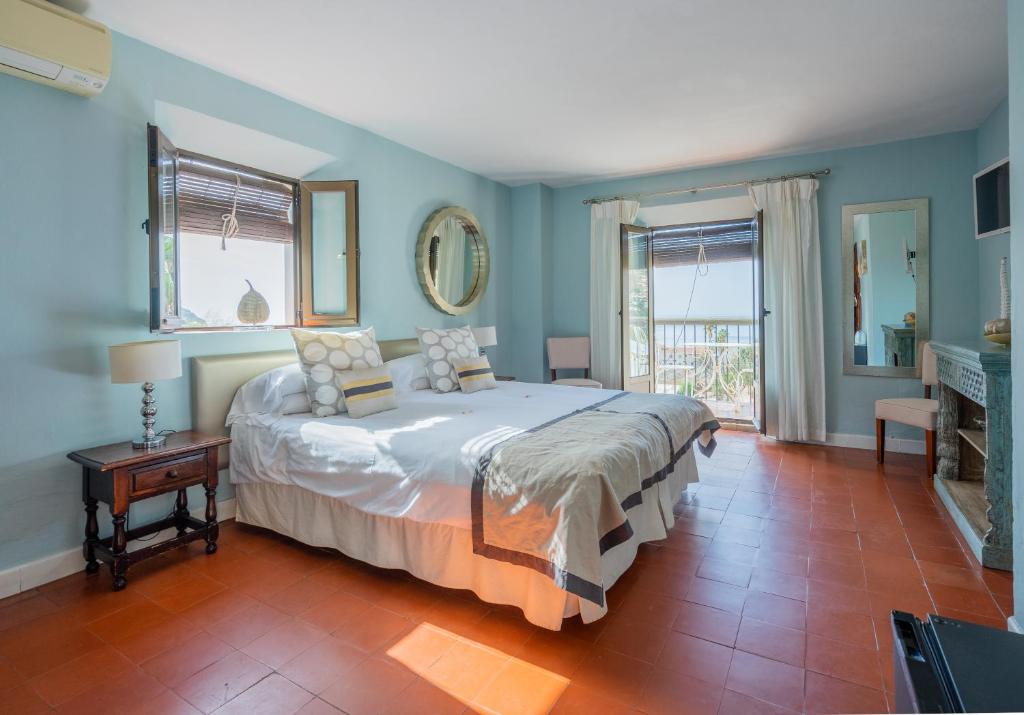 a bedroom with a large bed with blue walls at La Tartana Hotel Boutique in La Herradura