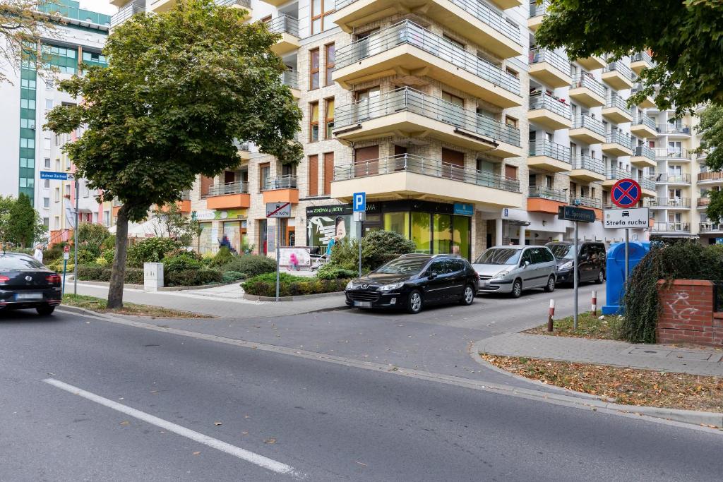 a street with cars parked in front of a building at Rezydencja Spacerowa Apartamenty by Renters in Kołobrzeg